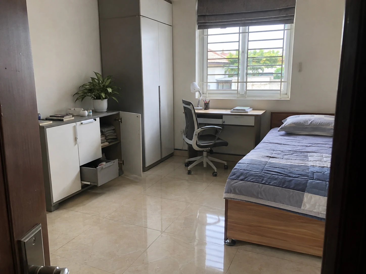 Lối đi giữa tủ, bàn học và giường trong phòng nhỏ