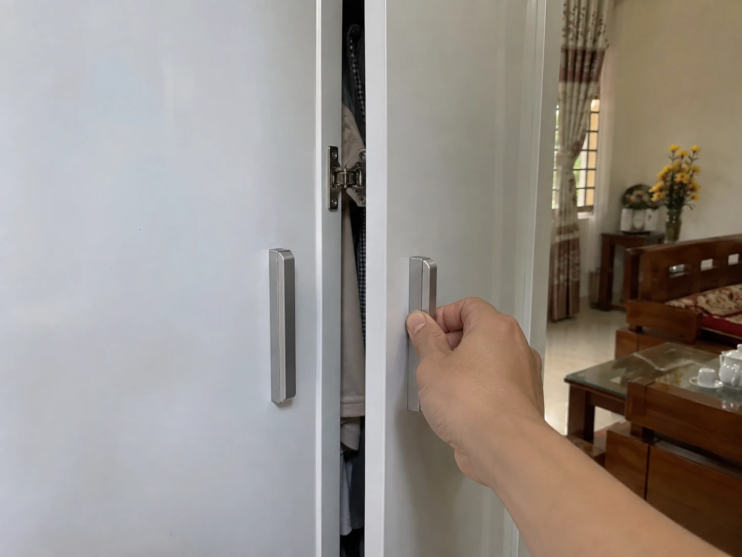 Người dùng quan sát bản lề và khe cánh tủ khi đóng mở
